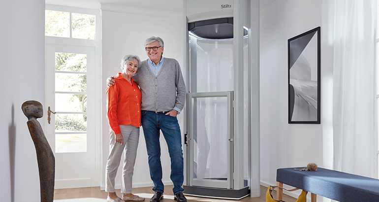 Home Elevators near Syracuse NY image of couple infront of their home elevator from Syracuse Elevator