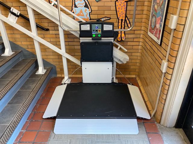 Syracuse-NY-Commercial-Wheelchair-Lift-Garaventa-from-Syracuse-Elevator-image-of-white-and-black-school-platform-lift-at-the-bottom